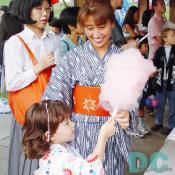 "Here you go." A mother was handing Wata-ame (cotton candy) to her daughter. 