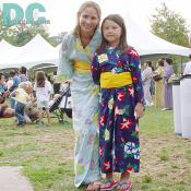 A daughter and a mother in nice kimonos gave a pose to the camera together. 
