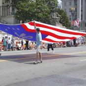 4 men holding the US. flag held high