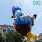 Giant bald eagle balloon wearing a vest and patriotic top hat.